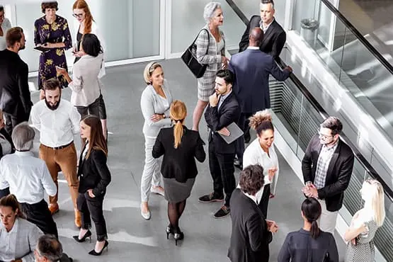 Professionnels échangeant lors d’un événement dans un hall.